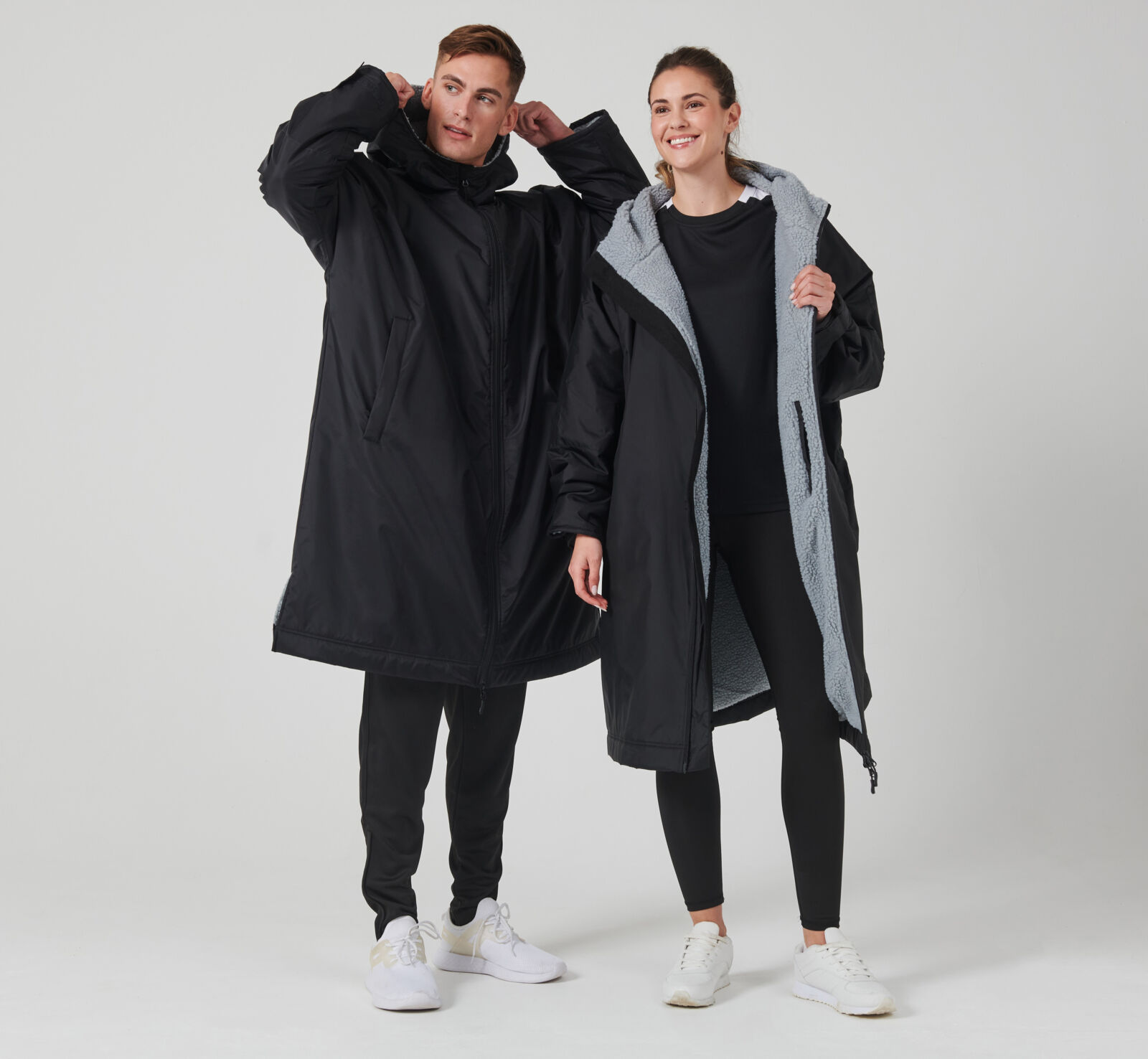 Man and women modelling black changing robes with grey fleece lining