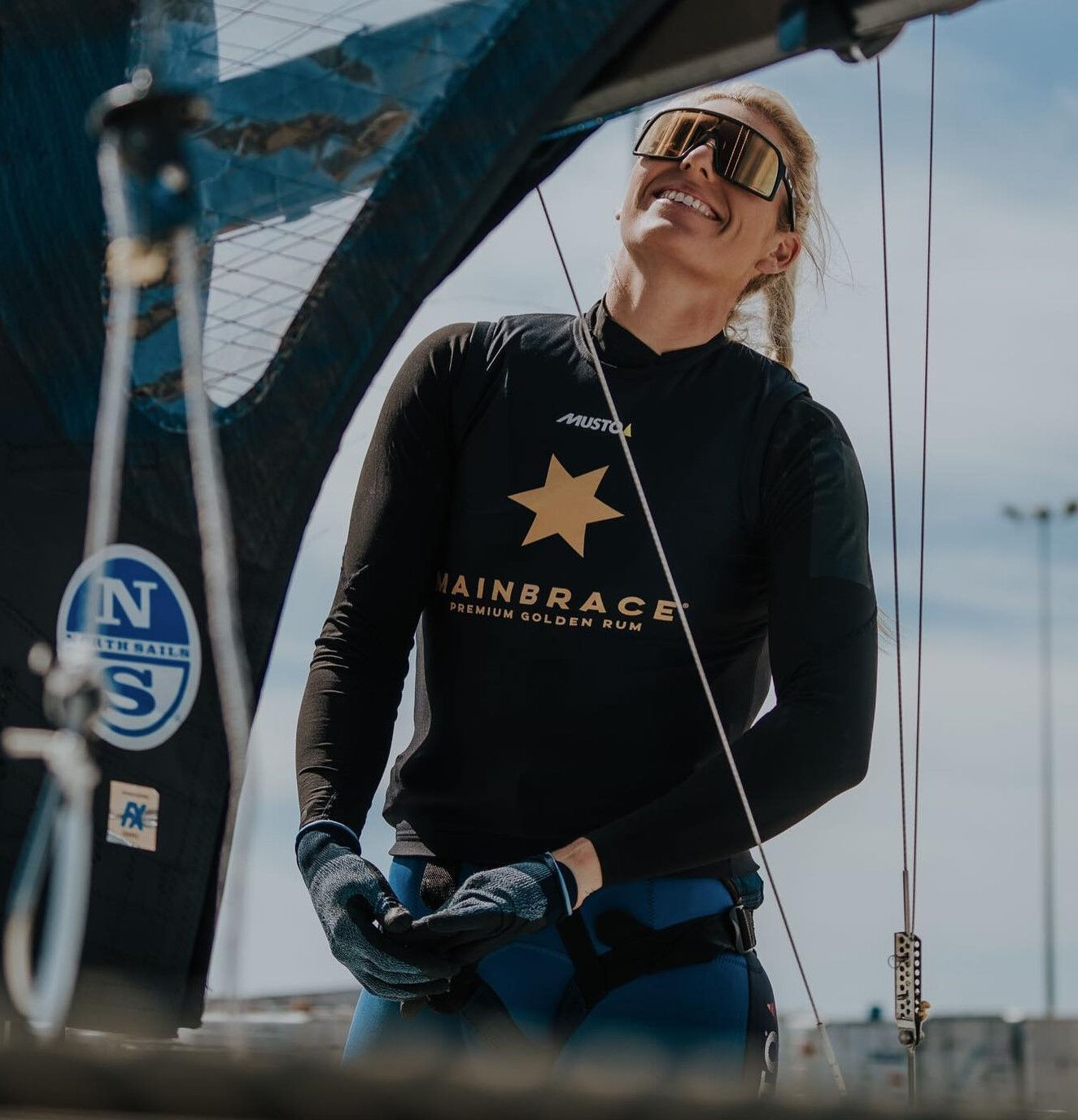 Female sailor looking at boat wearing a printed race bib