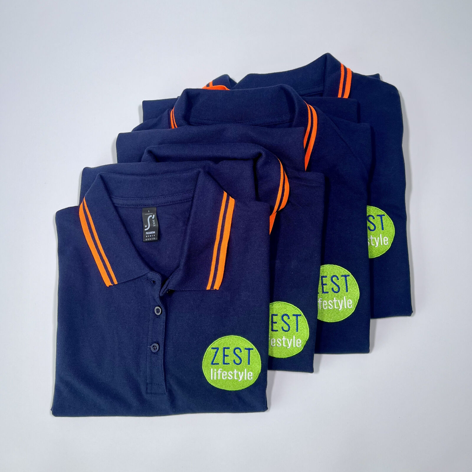 Navy and orange polo shirts with detailed green embroidery logo